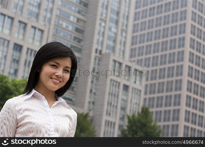 Smiling businesswoman near an office building