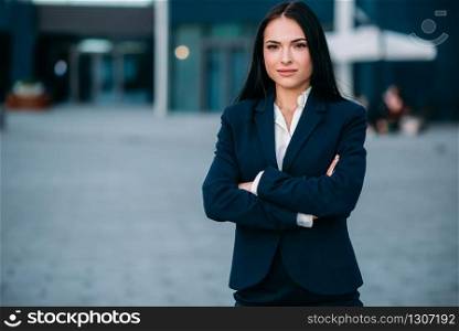 Smiling businesswoman poses against business center. Modern financial building, cityscape. Successful female businessperson. Businesswoman poses against business center