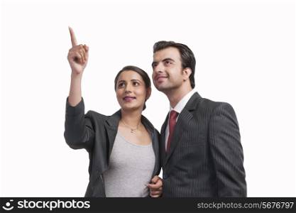 Smiling businesswoman showing something to colleague against white background