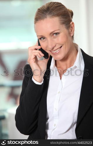 Smiling businesswoman using a telephone