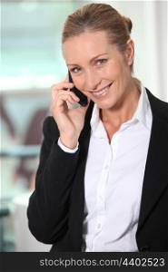 Smiling businesswoman using a telephone