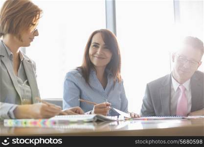 Smiling businesswoman with colleagues in meeting room