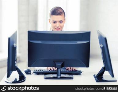 smiling businesswoman with computer and monitors in office. businesswoman with computer and monitors in office
