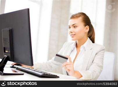 smiling businesswoman with computer using credit card
