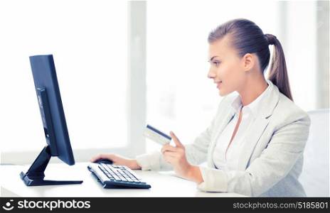 smiling businesswoman with computer using credit card. businesswoman with computer using credit card