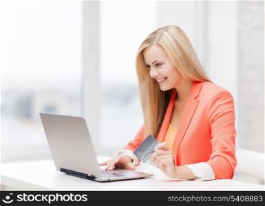 smiling businesswoman with laptop and credit card