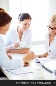 smiling businesswoman with team on meeting in office