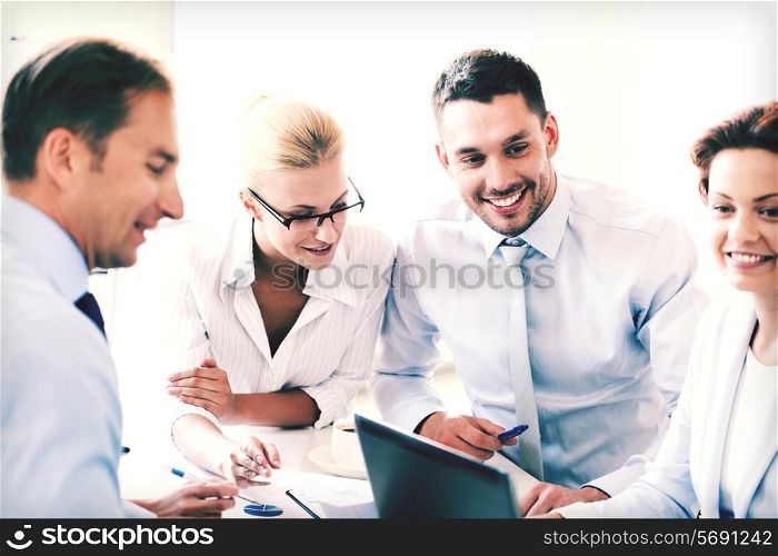 smiling businesswoman with team on meeting in office