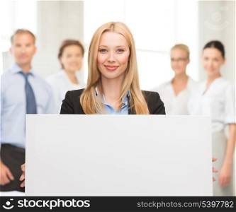 smiling businesswoman with white blank board in office