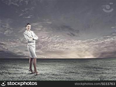 Smiling businesswoman. Young attractive businesswoman standing on green field
