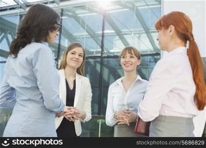 Smiling businesswomen conversing in office