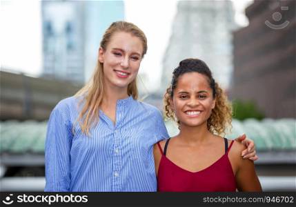 Smiling Businesswomen look at camera While Standing In City