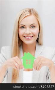 smiling busineswoman with green eco house symbol