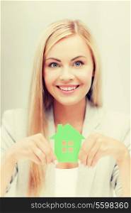 smiling busineswoman with green eco house symbol