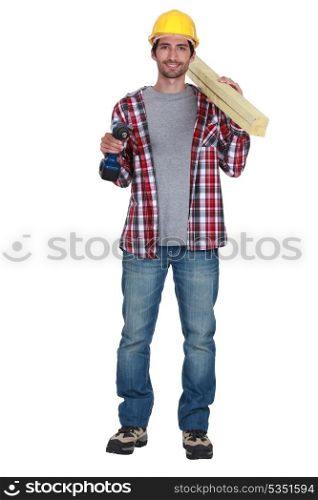 Smiling carpenter with drill and planks