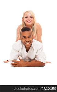 Smiling caucasian girl and black guy couple lying on the floor over white isolated background
