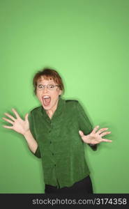 Smiling Caucasian mid-adult woman gesturing on green background.