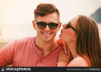 Smiling, cheerful and positive. Portrait of young happy couple dating outdoor at sea. Woman kissing man.