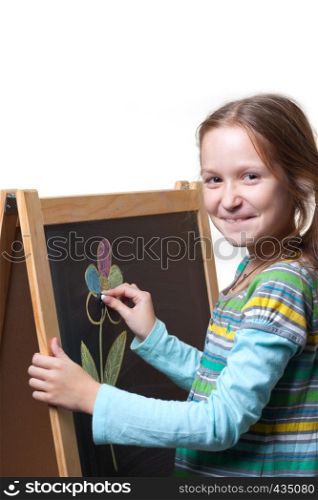 smiling child girl drawing with chalk on a wooden easel