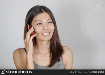 Smiling Chinese woman talking on smartphone