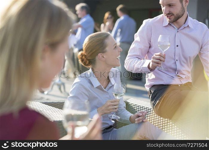 Smiling colleagues posing for mature businessman during rooftop party