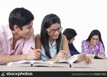 Smiling college students studying in classroom