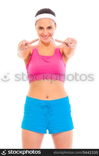 Smiling confident young girl in sportswear showing victory gesture isolated on white&#xA;