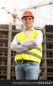 Smiling construction engineer in hardhat looking at camera