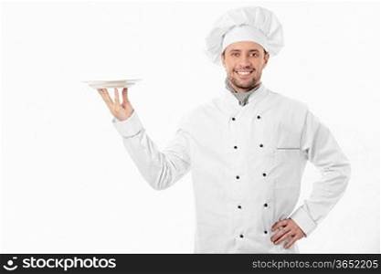 Smiling cook holding an empty plate on a white background