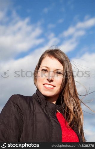 Smiling cool woman looking at camera with a beautiful sky of background