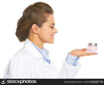 Smiling cosmetologist doctor woman presenting bottle of creme