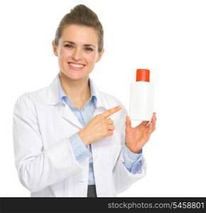 Smiling cosmetologist pointing on bottle of sunscreen