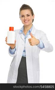 Smiling cosmetologist with bottle of sunscreen showing thumbs up