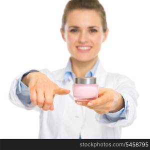 Smiling cosmetologist woman pointing on creme