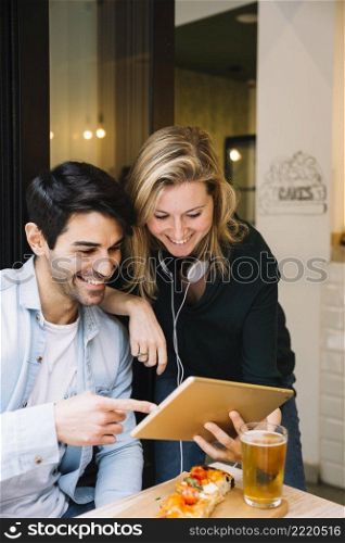 smiling couple cafe looking tablet