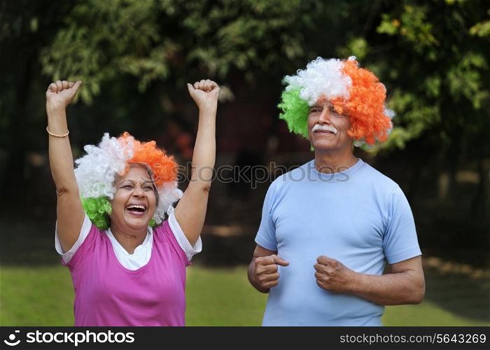 Smiling couple cheering at park