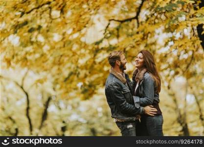 Smiling couple hugging in autumn park and having fun
