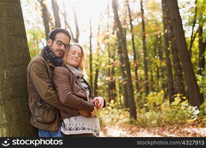 Smiling couple hugging in forest