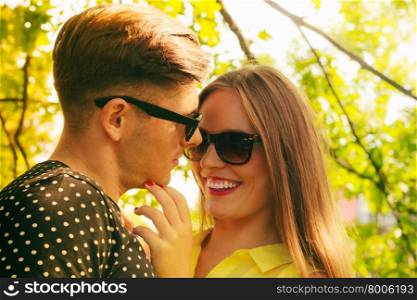Smiling couple in park. Love and happiness. Young happy joyful couple lovers wearing sunglasses dating in summer park outdoor.