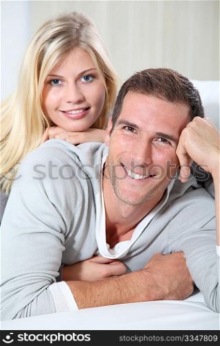 Smiling couple laying on sofa