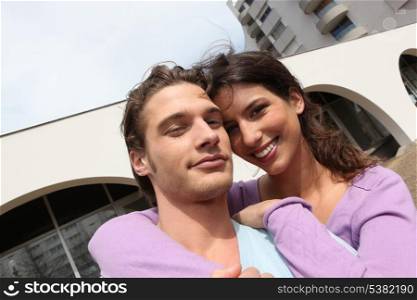 Smiling couple outside a block of flats
