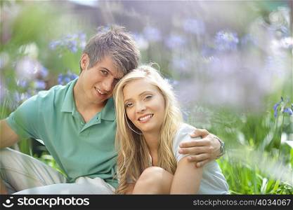 Smiling couple sitting in tall plants
