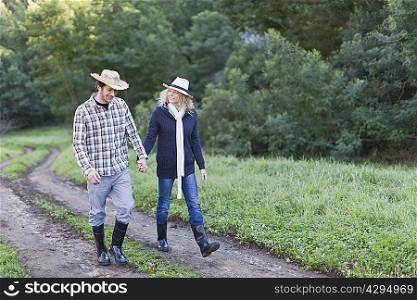 Smiling couple walking on dirt path