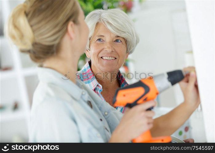 smiling daughter and grandmother working together