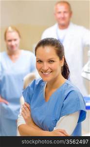 Smiling dental hygienist woman with stomatology team of medical professionals