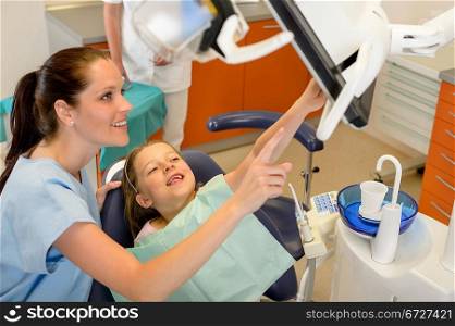 Smiling dentist and child pointing at the screen stomatology office