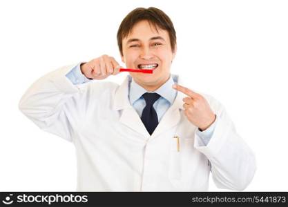 Smiling dentist pointing finger on toothbrush isolated on white. Concept - healty teeth &#xA;