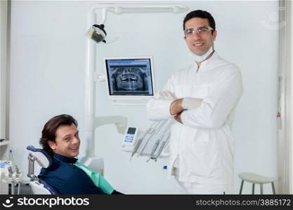 Smiling dentist with his patient in the dental studio
