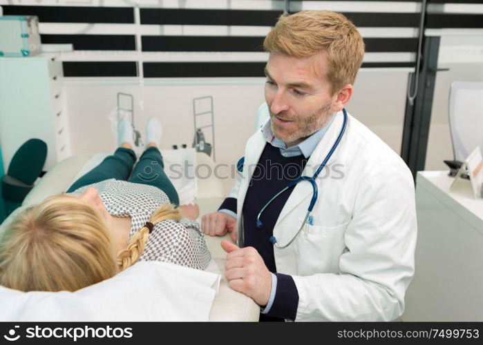 smiling dermatologist enjoying appointment with patient in the hospital