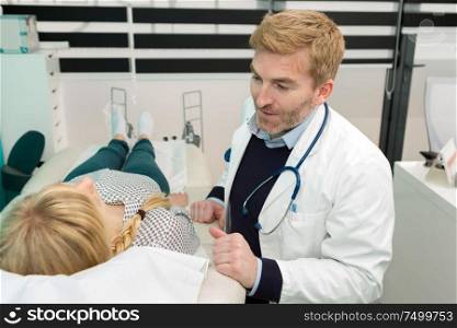 smiling dermatologist enjoying appointment with patient in the hospital